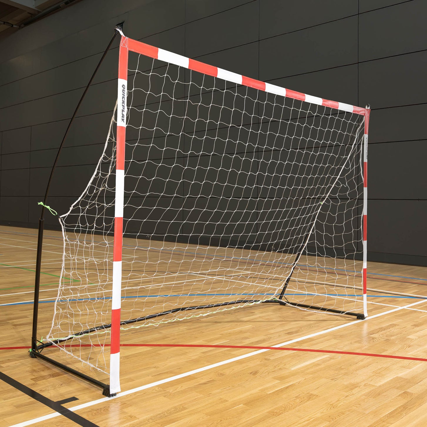 Draagbaar jeugdhandbaldoel 240 x 170 cm met rood-witte palen, wit net en zwart frame, in een sporthal.