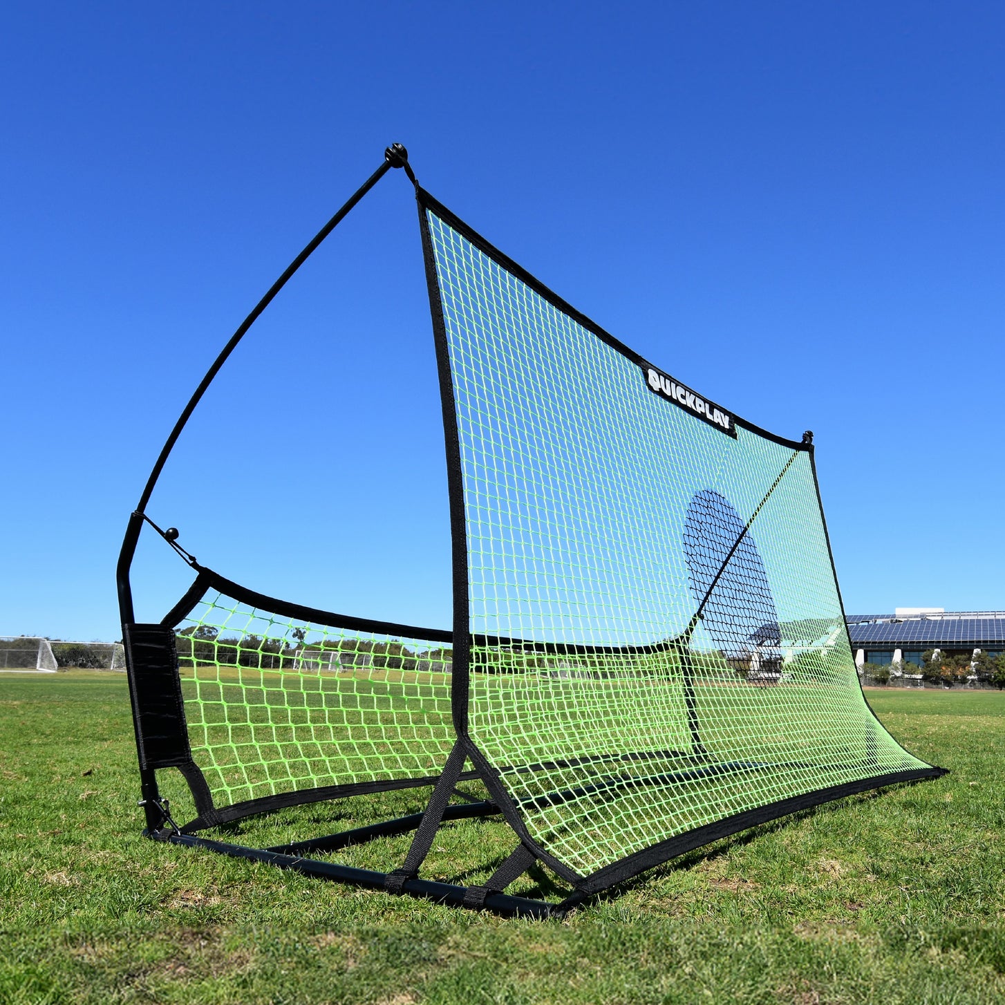 TEKKERS Trainer voetbalrebounder met dubbel net op het gras, met het grote groene net met een donkere doelcirkel en het onderste net.